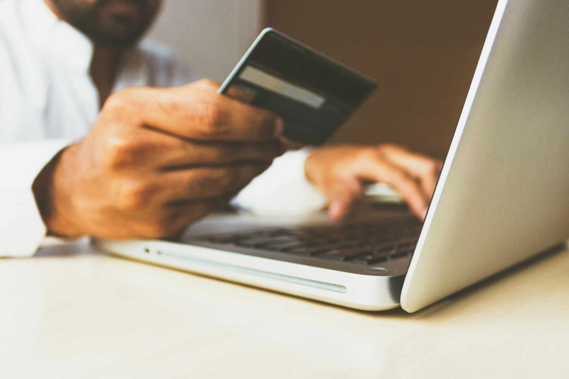Kupac unosi podatke kreditne kartice prilikom online kupovine na laptopu